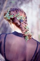 Rear view of blonde woman with braided hair wearing floral hair accessory