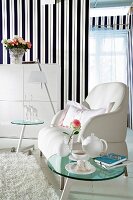 Striped wallpaper, white armchair, glass coffee table, side table and wardrobe