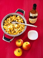 Three apples with pieces of apples in pan