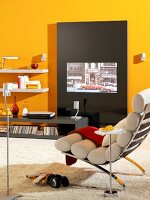 Room with yellow painted wall, recliner, wall unit and TV