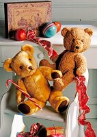 Two brown teddy bear on chair with decorations