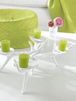 Leuchter aus Gips in Geweihoptik mit grünen Kerzen auf weißem Tisch