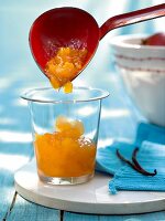 Jam being poured with trowel in glass kept on board