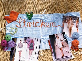 Decorated bath towel with ball of wool, glasses and different photos on bamboo mat
