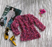 Pink and purple knitted sweater with yellow shoes on bamboo mat