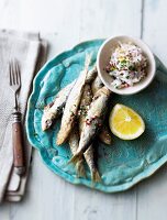 Fried sardines served with radishes and ricotta dip on serving plate