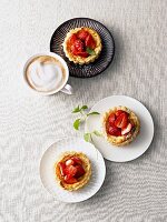 Small strawberry curd tarts and cappuccino