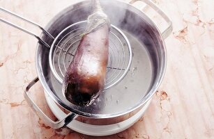 Aubergine mit Schaumkelle aus dem Topf nehmen, Step.