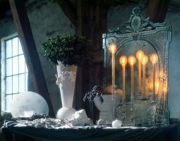 Weihnachtlich dekorierter Tisch mit Kerzen vor einem Spiegel, Vase
