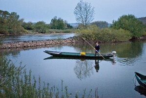 Man on boat fishing at Franconia, Germany