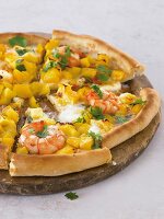 Close-up of round pizza with seafood on wooden platter