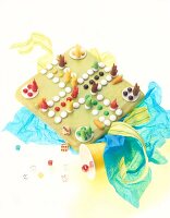 Colourful Easter cake in the shape of ludo game on white background