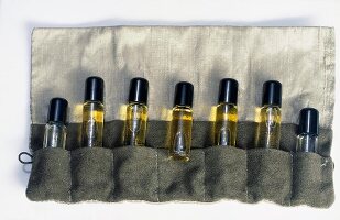 Various seven scent bottles in cloth bag