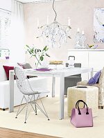Dining table, chairs, stools, handbag, chandelier and lit candles in dining room