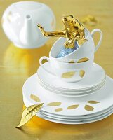 Stapel Teller und Tassen in Weiß mit Blättern in Gold bemalt, Goldfrosch