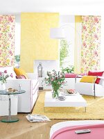 Wohnzimmer mit Möbel in Weiß, Farbakzente gelb, rosa, Blumenmotive