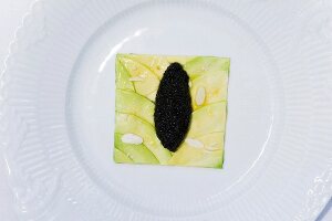 Close-up of avocado slice with caviar on plate