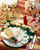 Table decorated festively with golden candlestick and roses, elevated view