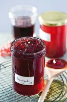 Close-up of dark red berry jelly in glass jar