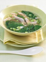 Chicken soup with spinach and leeks in bowl