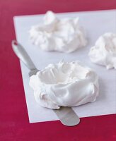 Close-up of meringues on baking paper while preparing raspberry pavlova