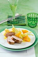 Pork fillet with orange and fennel on plate