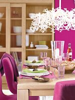 Tisch gedeckt in Pink und Grün, Teller und Leuchte weiß