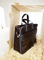 Large business bag in black with blue standing on wood chips