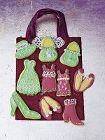Pink and green fashion biscuits shaped like handbags, dresses and shoes