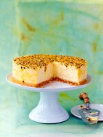 Passion fruit cheesecake on a cake stand, sliced