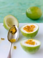 A passion fruit being scooped out