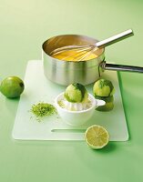 Lime on citrus juicer and cream in sauce pan on chopping board