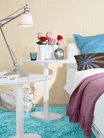 Bedroom in beige and white with round nightstand by bed