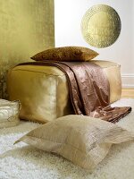 Golden pouf with copper pillow and quilt in gold and white room
