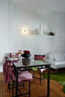 Table and chair with pink cover and champagne glasses on top with white sofa