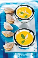 Mini calzone with ricotta and tomato filling on plate, carrot curry soup in bowl