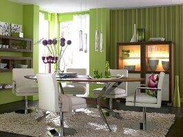 Dining room in green with white-brown round dining table and chairs