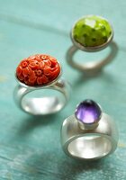 Close-up of red, blue and green stone rings