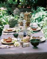 Table laid with antique ceramic crockery in garden, France