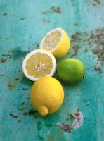 Limette und Zitronen (ganz und halbiert) auf Tisch