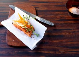Salmon on butter paper with knife on chopping board