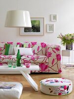 Living room with pink magnolia sofa, lamp, coffee table and seat cushion on wooden floor