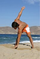 Mann macht Gymnastik am Strand