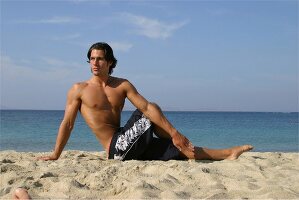 Mann macht Gymnastik am Strand