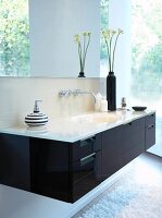 Bathroom with white washbasin in black cabinet