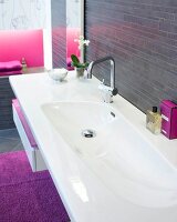 White long sink with perfume against black wall and purple carpet