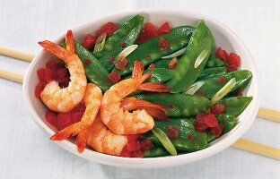 King prawns with sugar snap peas and tomatoes on plate