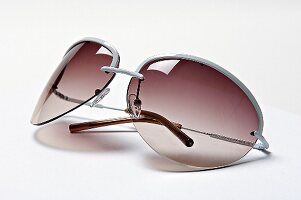 Sonnenbrille mit Metallbügeln und rötlich getönten Gläsern