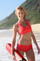 Frau blond am Strand, Blick in die Kamera im roten Bikini