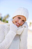 Portrait of pretty woman hair wearing white winter sweater, smiling